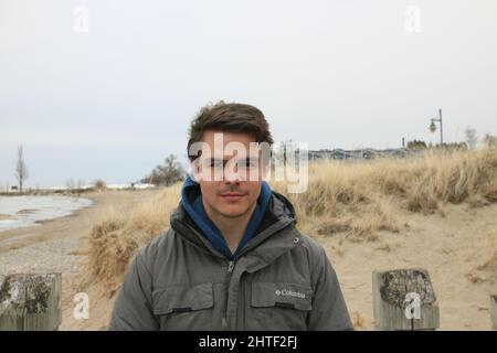 Schöne Aufnahme eines jungen kaukasischen Mannes, der für die Kamera posiert Stockfoto