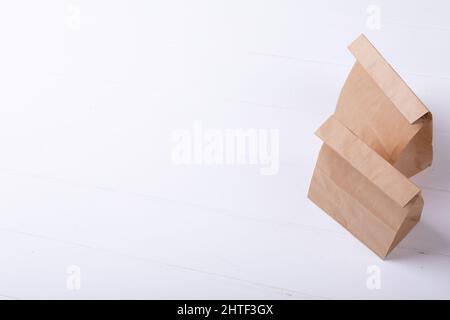 Hochwinkelansicht von braunen Papiertüten auf weißem Hintergrund mit Platz zum Kopieren Stockfoto