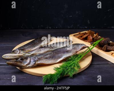 Sonnengetrockneter Fisch, gesalzene Schmelzen auf Holzgrund Stockfoto