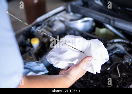 Automechaniker, der den Motorölstand eines Autos in einer Garage überprüft Stockfoto