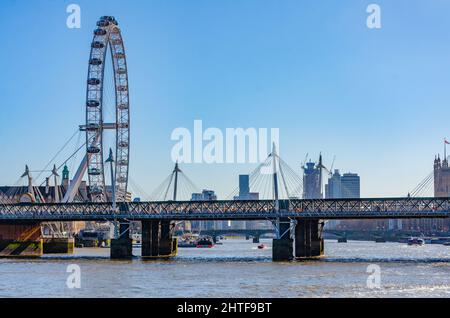 Blick über die Themse in London vom Victoria Embankment auf die Golden Jubilee Bridges und das London Eye Stockfoto