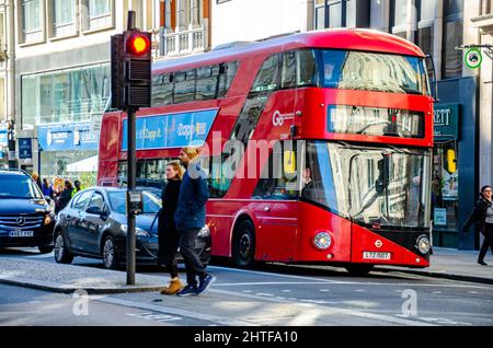 Ein roter Londoner Doppeldeckerbus hielt an einer roten Ampel am Strand in der City of Westminster, London, Großbritannien Stockfoto