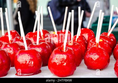 Rote Toffee-Äpfel auf Stöcken, die auf einem Markt verkauft werden Stockfoto