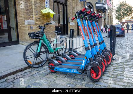 Blaue, straßenzugelassene Elektroroller können in der Gegend von Covent Garden in London, Großbritannien, gemietet werden Stockfoto