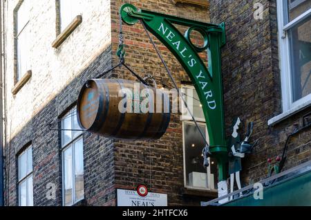 Ein Fass, das an einer Wand am Eingang zu Neal's Yard in der Nähe von Covent Garden in London, Großbritannien, hängt Stockfoto