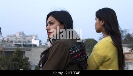 Nahaufnahme von zwei jungen südasiatischen Weibchen auf einem Balkon Stockfoto