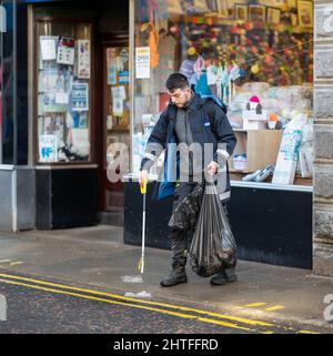 25. Februar 2022. South Street, Elgin, Moray, Schottland. Dies ist ein Männchen, das aus den Straßen von Elgin Wurf sammelt. Stockfoto