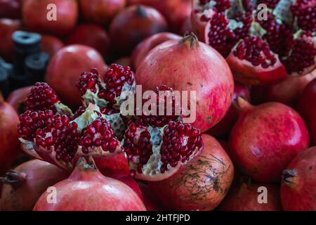 Nahaufnahme von hellen Früchten für Hintergrund, Textur. Rote reife Granatäpfel auf dem Display. Stockfoto