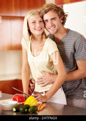 Romantik in der Küche. Porträt eines glücklichen jungen Paares, das in der Küche steht. Stockfoto