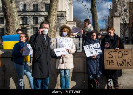 Demonstranten, die Plakate mit „Stop the war“ halten, gegenüber der Downing Street in Whitehall, London, Großbritannien Stockfoto