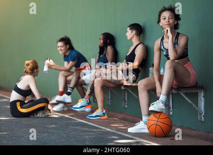 Denken Sie, Sie haben das Zeug dazu. In voller Länge Porträt einer attraktiven jungen Sportlerin, die mit ihr auf einer Bank am Basketballplatz sitzt Stockfoto