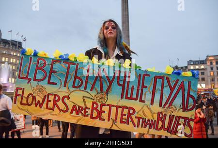 London, Großbritannien. 28.. Februar 2022. Ein Protestler hält ein Plakat mit der Aufschrift „Blumen sind besser als Kugeln“. Hunderte von Menschen versammelten sich am sechsten Tag der Proteste auf dem Trafalgar Square, während der Krieg in der Ukraine andauert. Kredit: Vuk Valcic/Alamy Live Nachrichten Stockfoto