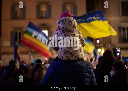 Brescia, Brescia, Italien. 28.. Februar 2022. Demonstration gegen den Krieg in der Ukraine ein Kind auf den Schultern seines Vaters auf der Piazza Loggia mit ukrainischen Flaggen (Foto: © Matteo Biatta/ZUMA Press Wire) Stockfoto