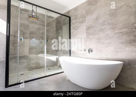 Leere Badewanne durch moderne Dusche im Badezimmer zu Hause Stockfoto