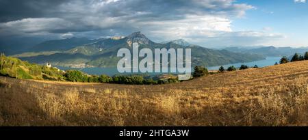 Serre-Poncon See im Sommer mit nahenden Sturm. Panoramablick auf die Dörfer Saint-Apollinaire und Savines-le-Lac. Hautes-Alpes (Alpen), Frankreich Stockfoto