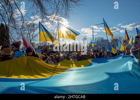 Warschau, 27. Februar 2022: Protest gegen den Krieg in der Ukraine und die russische Invasion. Menschen marschieren mit Flaggen bei der Demonstration zur Unterstützung der Ukraine Stockfoto