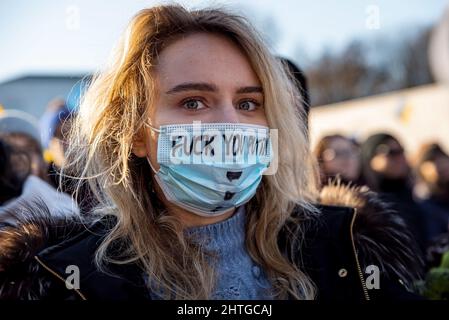 Warschau, 27. Februar 2022: Protest gegen den Krieg in der Ukraine und die russische Invasion. Frau mit Maske und Text auf dem Demonstrationsstand mit der Ukraine Stockfoto