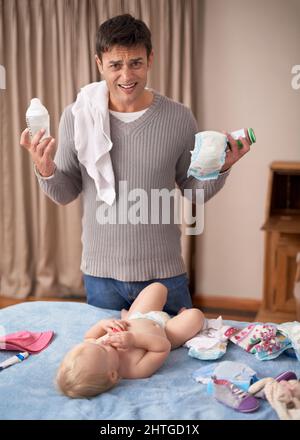 So viele Verantwortlichkeiten ist es nicht einfach, ein alleinerziehender Elternteil zu sein. Ein junger Vater sieht überwältigt aus, während er neben seiner kleinen Tochter steht. Stockfoto