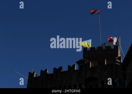 Cagnes sur Mer, Frankreich - 28. Februar 2022: Die ukrainische Flagge wird solidarisch auf Château Grimaldi geflogen, die vor dunklem Hintergrund hervorgehoben wird. Stockfoto