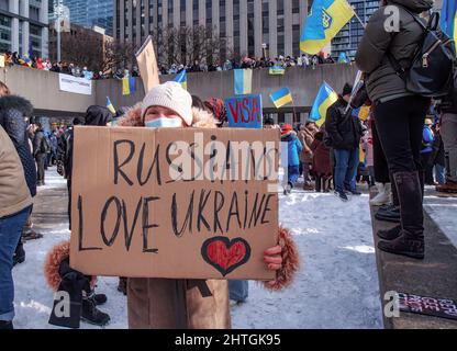 Toronto, Ontario/Kanada - 27. Februar 2022: Eine ältere Dame mit russischer Herkunft hält ein Plakat mit handgeschriebener Notiz.Russen lieben die Ukraine bei Torontos Mega-marsch und Kundgebung, um die Ukraine zu unterstützen und Putins Invasion zu verurteilen. Stockfoto