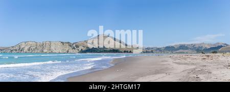 Panoramablick auf die Tolaga Bay mit den umliegenden Hügeln unter blauem Himmel, Ostküste Neuseelands. Stockfoto