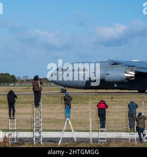 Flugzeugbeobachter auf dem Flugfeld von Mildehall machen Fotos von der Boeing C-17 Globemaster III Taxi-ing Stockfoto