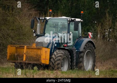 Der Fendt 720 Traktor ist mit einem gelben Twose-Schnellkuppelkasten ausgestattet und fährt auf einer Landstraße Stockfoto