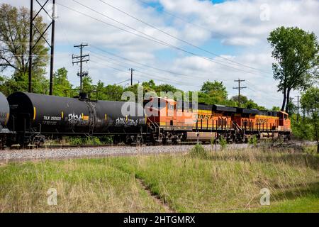 BNSF-Dieselmotoren, die einen Eisenbahnzug mit Tankwagen im Vordergrund ziehen. Minneapolis Minnesota, USA Stockfoto