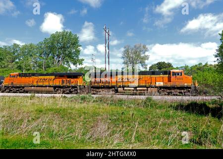 Der leistungsstarke zweimotorige BNSF-Zug bewegt sich entlang der Gleise und zieht Güterwagen an ihr Ziel. Minneapolis Minnesota, USA Stockfoto