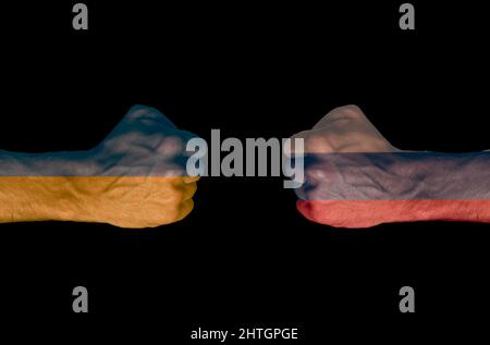 Abbildung der Flaggen der Ukraine und Russlands auf zwei einander gegenüberliegende Fäuste auf schwarzem Hintergrund. Bewaffneter Konflikt Stockfoto