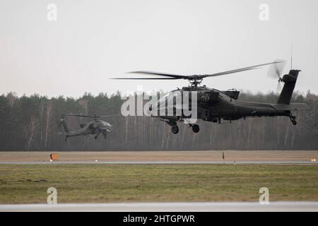 Lask, Polen. 22. Februar 2022. Zwei Hubschrauber der US Army AH64 Apache-Delta mit der 12. Combat Aviation Brigade auf der Lask Air Base am 22. Februar 2022 in Lask, Polen. Die USA haben die NATO-Truppen in der Region verstärkt, um der russischen Bedrohung gegen die Ukraine entgegenzuwirken. Kredit: TSgt. Jacob Albers/U.S. Air Force/Alamy Live News Stockfoto