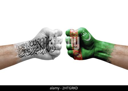 Zwei Hände schlagen sich gegenseitig auf weißem Hintergrund zu. Länderflaggen bemalten Fäuste, Konfliktkrisenkonzept zwischen afghanistan und turkmenistan Stockfoto