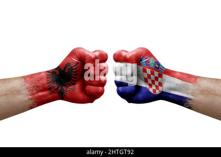 Zwei Hände schlagen sich gegenseitig auf weißem Hintergrund zu. Länderflaggen bemalten Fäuste, Konfliktkrisenkonzept zwischen albanien und kroatien Stockfoto