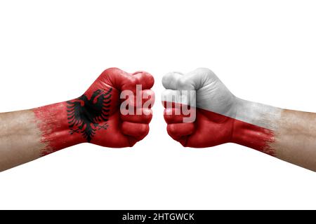 Zwei Hände schlagen sich gegenseitig auf weißem Hintergrund zu. Länderflaggen bemalten Fäuste, Konfliktkrisenkonzept zwischen albanien und polen Stockfoto