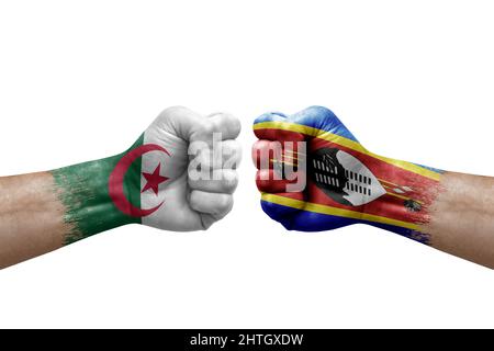 Zwei Hände schlagen sich gegenseitig auf weißem Hintergrund zu. Länderflaggen bemalten Fäuste, Konfliktkrisenkonzept zwischen algerien und eswatini Stockfoto