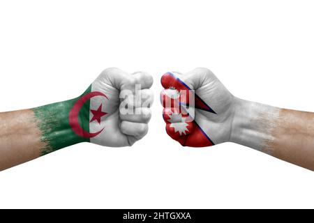 Zwei Hände schlagen sich gegenseitig auf weißem Hintergrund zu. Länderflaggen bemalten Fäuste, Konfliktkrisenkonzept zwischen algerien und nepal Stockfoto