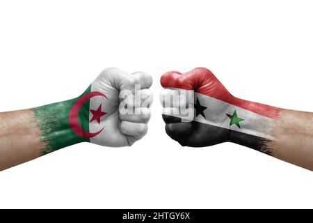 Zwei Hände schlagen sich gegenseitig auf weißem Hintergrund zu. Länderflaggen bemalten Fäuste, Konfliktkrisenkonzept zwischen algerien und syrien Stockfoto