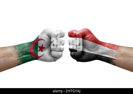 Zwei Hände schlagen sich gegenseitig auf weißem Hintergrund zu. Länderflaggen bemalten Fäuste, Konfliktkrisenkonzept zwischen algerien und jemen Stockfoto
