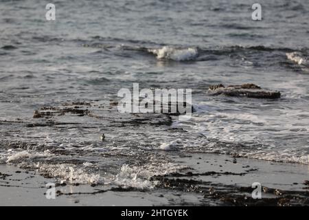 Verschwommener abstrakter natürlicher Hintergrund des Meerwassers mit Wellen und Schaum. Bewegungsunschärfe. Natur. Stockfoto