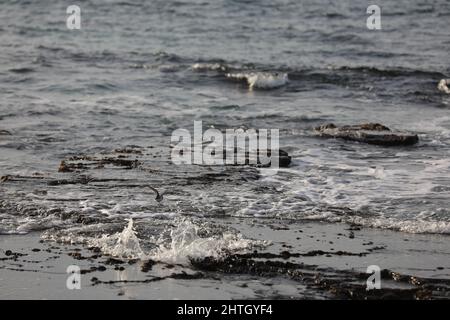 Verschwommener abstrakter natürlicher Hintergrund des Meerwassers mit Wellen und Schaum. Bewegungsunschärfe. Natur. Stockfoto