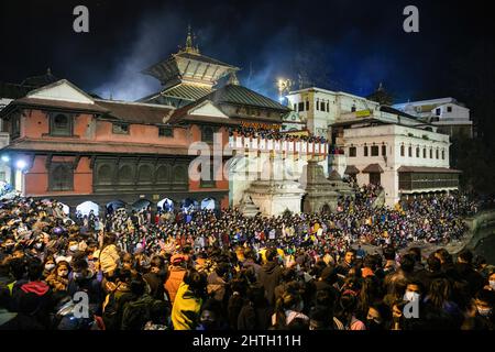 Kathmandu, Nepal. 28.. Februar 2022. Hindu-Anhänger versammeln sich, um die religiösen Rituale zu beobachten und am Vorabend des Maha Shivaratri-Festivals in den Räumlichkeiten des Pashupatinath-Tempels zu tanzen. (Foto: Prabin Ranabhat/SOPA Images/Sipa USA) Quelle: SIPA USA/Alamy Live News Stockfoto