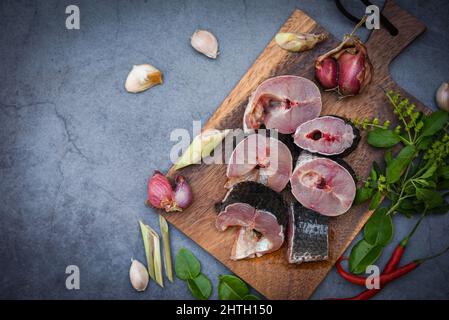 Schlangenkopf-Fisch zum Kochen von Lebensmitteln, gestreifter Schlangenkopf-Fisch, gehackt mit Zutaten Kräuter und Gewürze auf Holzschneidebrett und Tischküche Hintergrund, Stockfoto
