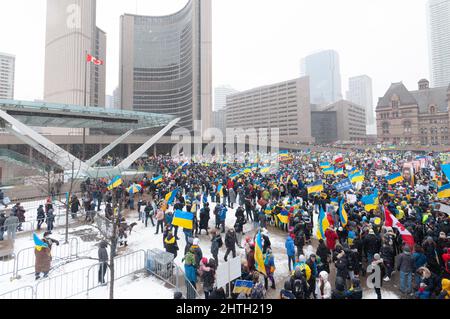 Toronto, Ontario, Kanada – 27. Februar 2022: Demonstranten mit Transparenten und ukrainischen Fahnen auf dem Nathan Phillips Platz in der Innenstadt während einer Demonstration Stockfoto