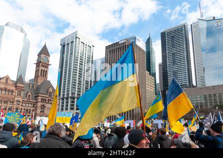 Toronto, Ontario, Kanada – 27. Februar 2022: Demonstranten mit Transparenten und ukrainischen Fahnen auf dem Nathan Phillips Platz in der Innenstadt während einer Demonstration Stockfoto