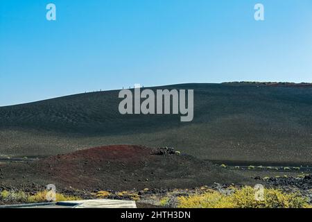 Wanderer auf dem Gipfel des Inferno Cone am Craters of the Moon National Monument, Idaho, USA Stockfoto