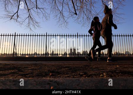 Menschen, die alleine den Weg des Central Park Reservoir mit der Skyline des Central Park West im Hintergrund laufen.New York City.NY.USA Stockfoto