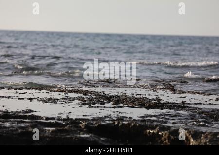 Verschwommener abstrakter natürlicher Hintergrund des Meerwassers mit Wellen und Schaum. Bewegungsunschärfe. Natur. Stockfoto