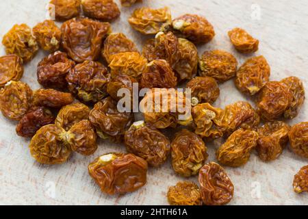 Getrocknete Bio-Goldbeere (Physalis peruviana) auf Holzbrett Nahaufnahme Stockfoto