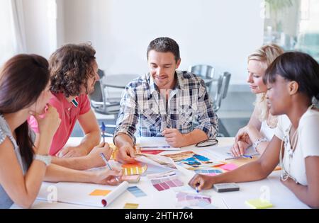 Die Wahl des perfekten Farbtons. Eine Gruppe von Innenarchitekten, die in ihrem Atelier über Farben entscheiden. Stockfoto