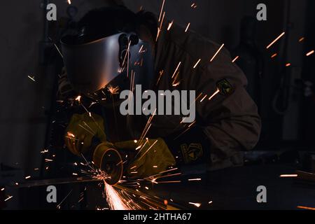 MISAWA, Japan (Feb 6, 2022) – Ian Acuzar, Chief Hull Technician, der der Naval Air Facility Misawa zugewiesen wurde, verwendet eine Metall-Kreissäge in einem Hobbygeschäft im Luftwaffenstützpunkt Misawa. Acuzar schneidet Metall regelmäßig, um Menschen das Schweißen beizubringen, weil er der Meinung ist, dass es eine nützliche Fähigkeit ist, die jeder haben sollte. (USA Navy Foto von Mass Communication Specialist 3. Klasse Benjamin Ringers) Stockfoto